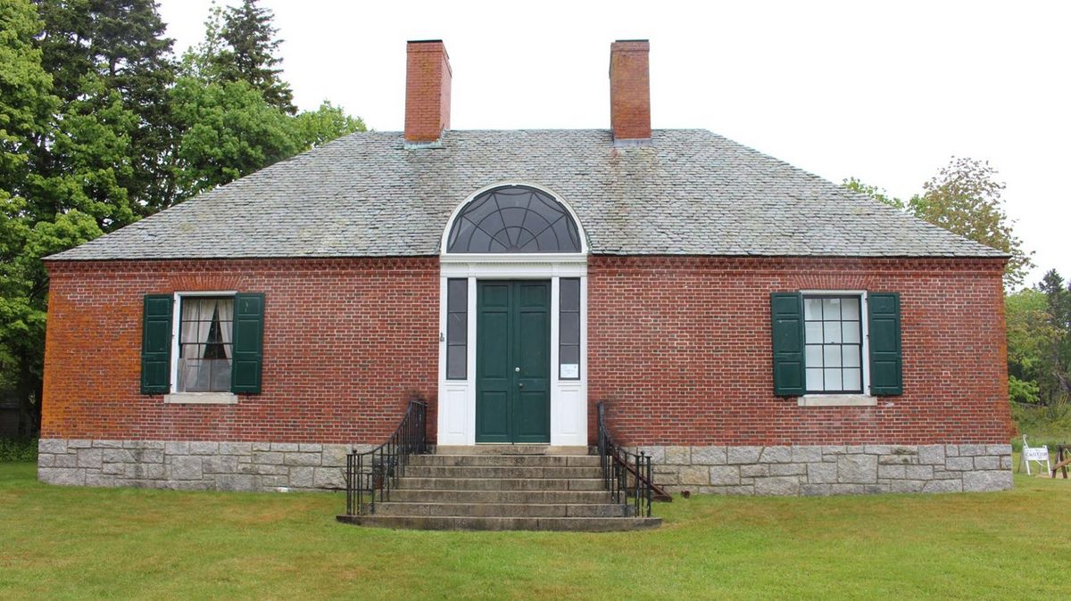 Brick Islesford Historical Museum building with green shutters