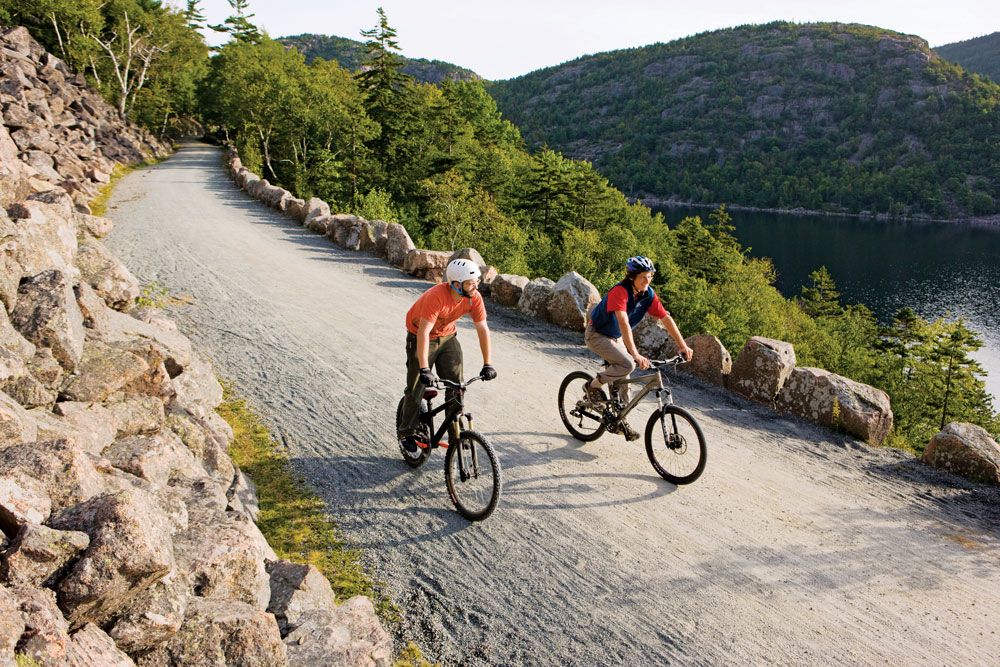 Cyclists riding an Acadia carriage road above Jordan Pond